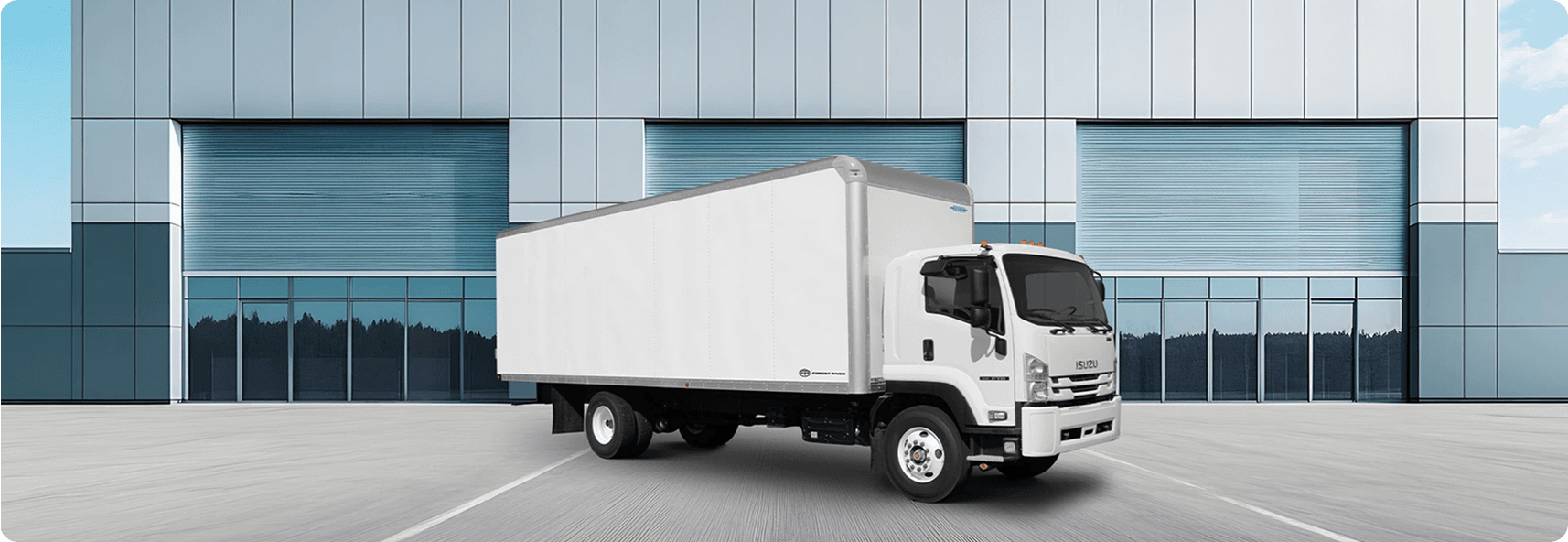 White box truck parked outside a warehouse